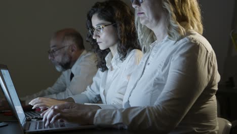 Coworkers-using-computers-in-dark-office